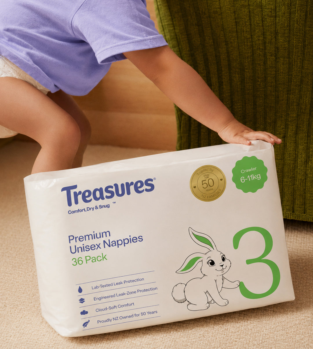 A toddler reaches for a Treasures size 3 36 pack on the floor